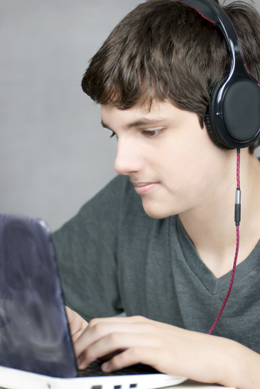 Headphone Wearing Teen Works On Computer
